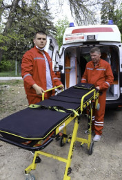 Фельдшеры с пустой каталкой у машины скорой помощи
